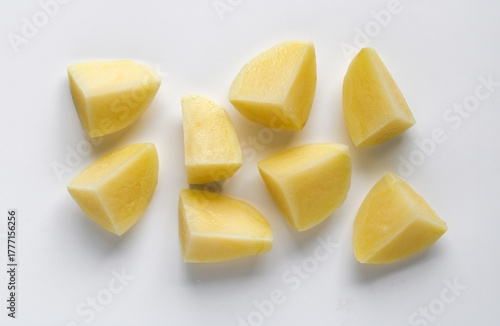 Foto Several chunks of raw potato arranged on a white background, showing the smooth texture and yellow flesh