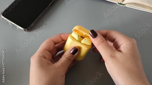 Wallpaper Mural Female hands taking earphones out of the case, phone on the table, concept of listening to music, audiobooks Torontodigital.ca