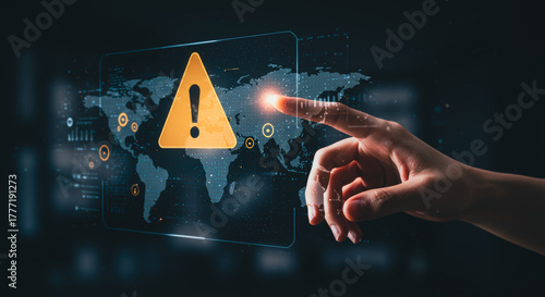 A hand interacts with a digital display showing a world map and a warning icon, symbolizing global alerts and technological risk.