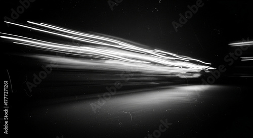 Abstract light trails from moving vehicle at night, captured with long exposure in black and white