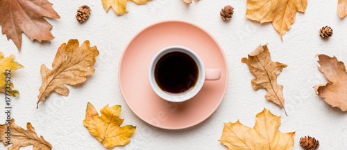 Flat lay composition with colorful Autumn cup of coffee and leaves on a color background. top view