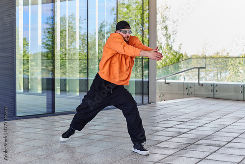 A modern man in informal clothes shows the plasticity of the body and dances tectonics