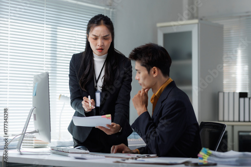 Woman discussing document problem with confused man