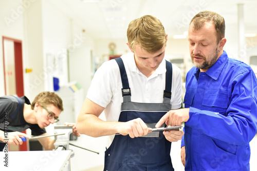 Group of young people in mechanical vocational training with teacher