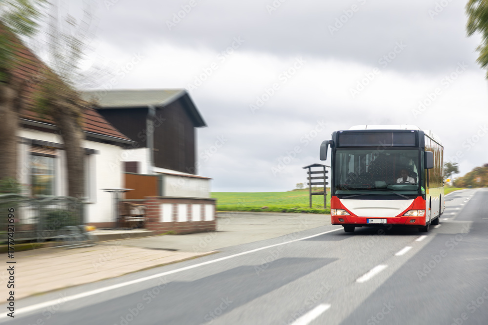 Fototapeta premium City bus on rural road. Public transport in motion.