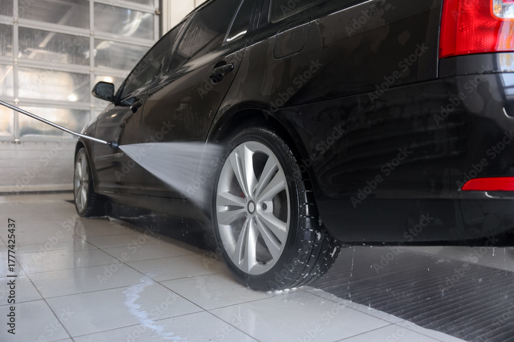 Fototapeta premium Washing auto with high pressure water jet at car wash, closeup