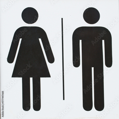 Simple black and white restroom sign showing male and female symbols separated by a line. Minimalist pictogram design commonly used to indicate public toilets or washrooms. 