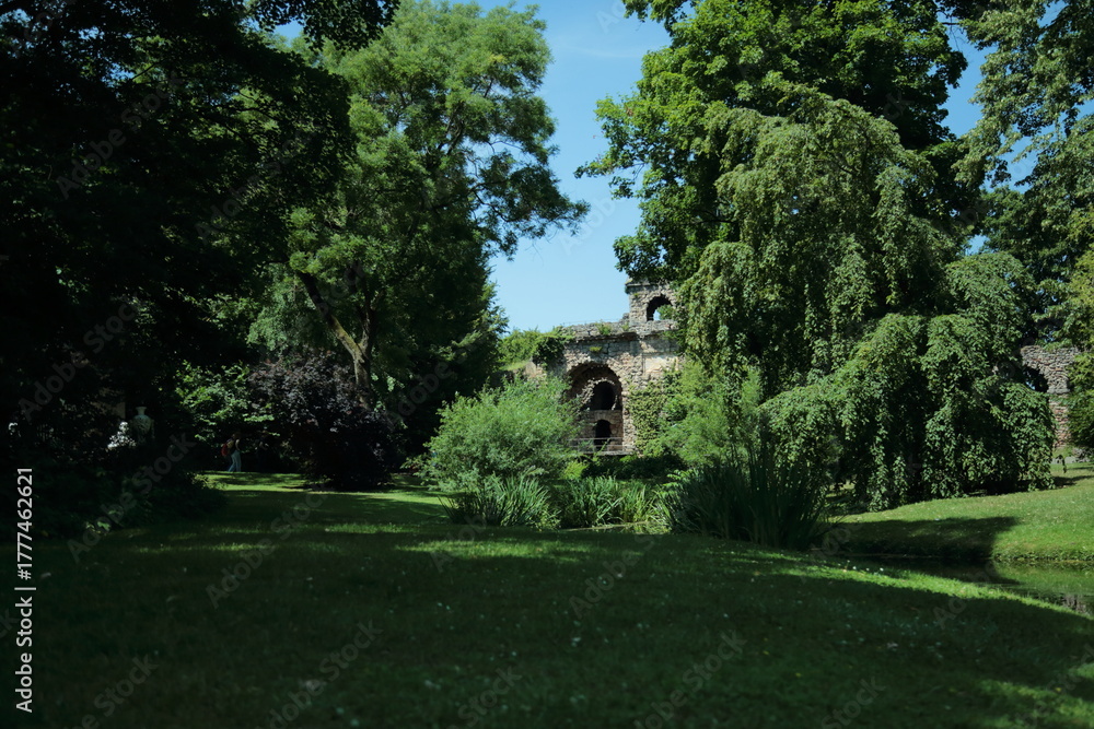 Obraz premium Lush green park landscape with old stone ruins