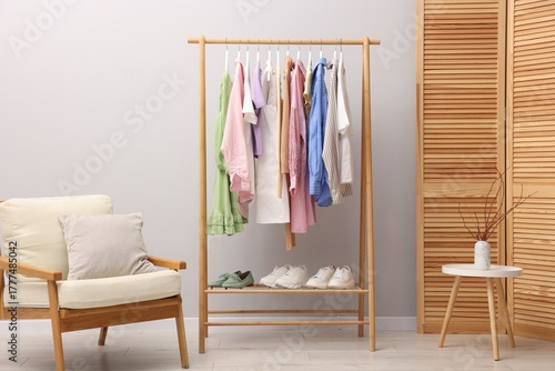 Wallpaper Mural Different stylish clothes hanging on rack, shoes and armchair near light wall indoors Torontodigital.ca