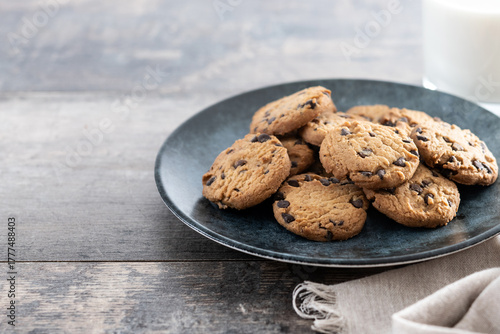 Chocolate chip cookies and milk for breakfast on wooden table. Copy space