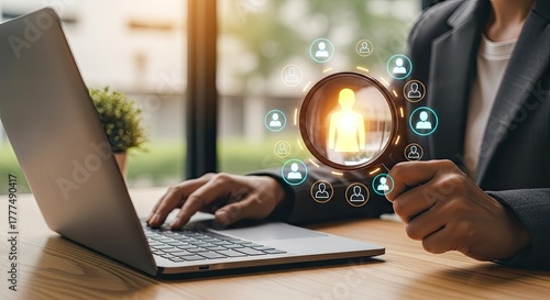 Person Magnifying Candidate Icons While Typing on Laptop with Blazer on at Desk