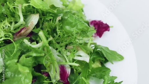 Fresh mixed salad field greens piled close up view.