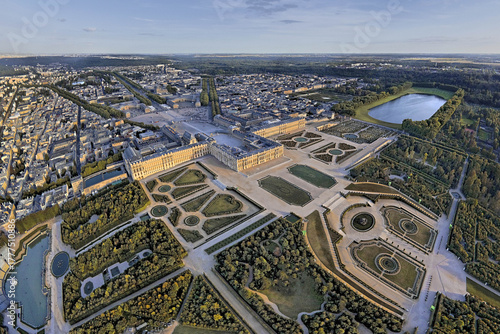 Versailles, France - 04 November 2025: Aerial view of the Palace of Versailles and its elaborate gardens, a symphony of structured greenery and reflective water features.