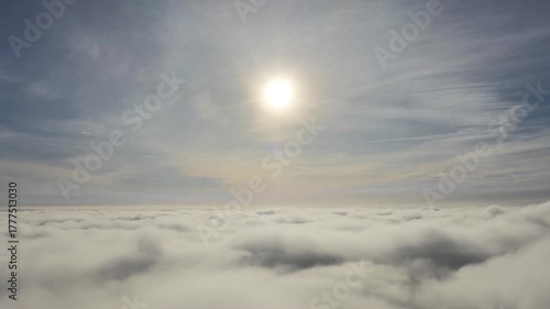 Aerial drone view of industrial chimneys emitting steam above thick fog and clouds on a sunny day, power plant and factory landscape. Panorama above clouds in fog in sunny day. Clouds factory