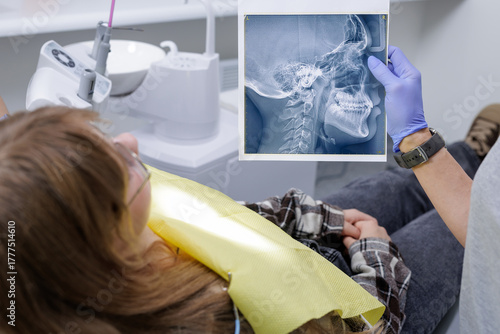 Orthodontist showing lateral cephalometric xray to patient during clinic consultation