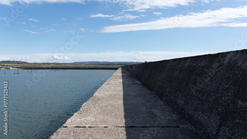 Long Concrete Breakwater under Clear Blue Sky