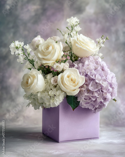 Pastel lavender box with hydrangeas and white roses, neutral grey background, soft overcast glow, premium floral catalog style