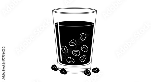 A glass of dark liquid with seeds inside and scattered around the base.