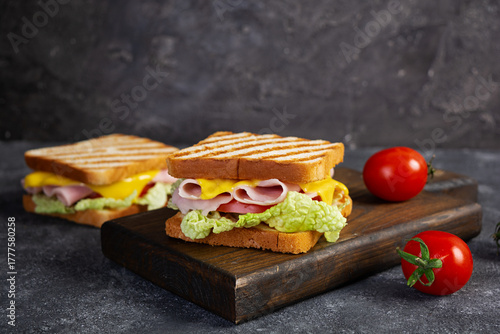 Delicious sandwich with ham, cheese, tomato and lettuce on toasted bread. Perfect lunch or snack idea