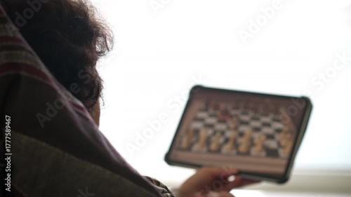 Senior Woman Using Tablet to Play Chess