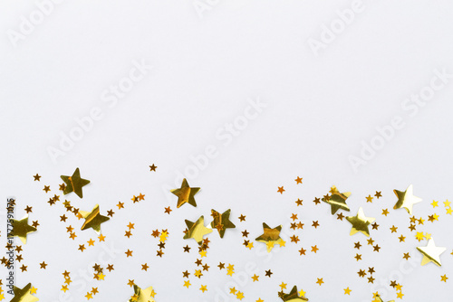 Golden star shape confetti on color background, top view