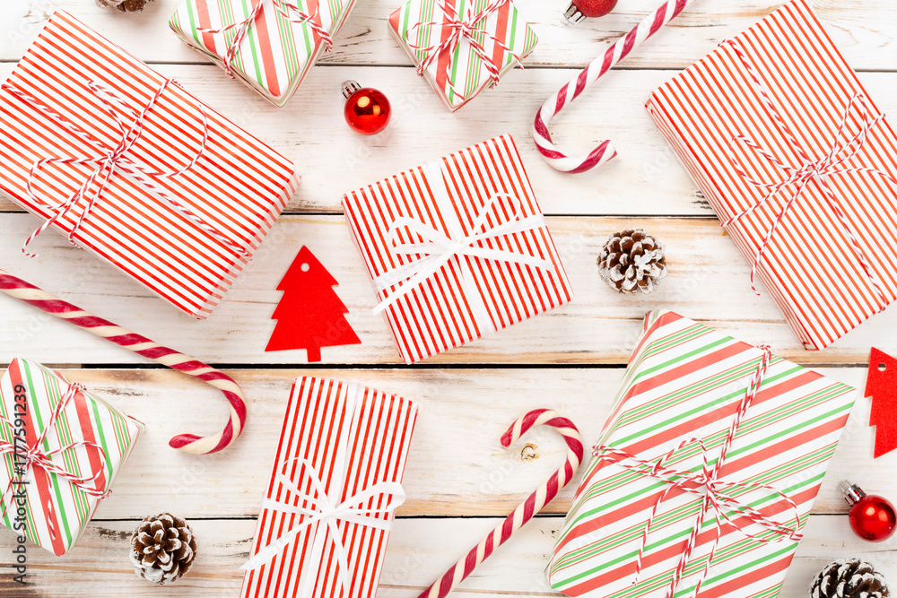 Obraz premium Many striped Christmas gift boxes on wooden background, top view