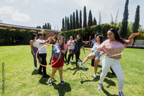 Obraz na płótnie Diverse large group of latin american people playing with hula hoop outdoors in Mexico