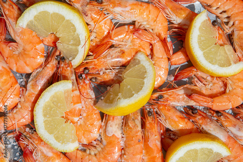 Top view of cooked shrimps with lemon under hard sunlight