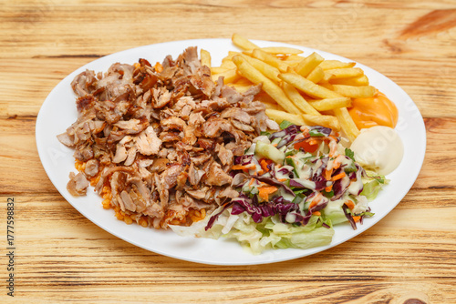 Assiette kebab servie avec blé, frites et salade – restauration rapide turque halal. Doner kebab