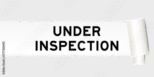 Ripped gray paper background that have word under inspection under torn part