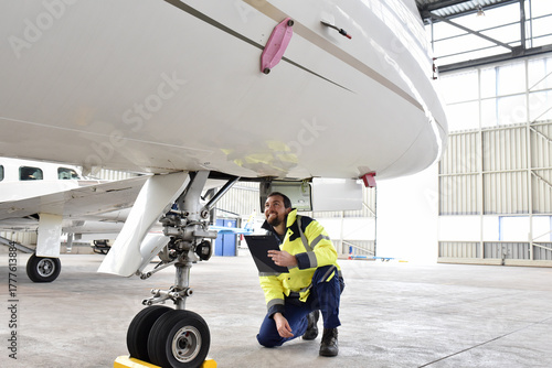Aircraft mechanic inspects and checks the technology of a jet in a hangar at the airport