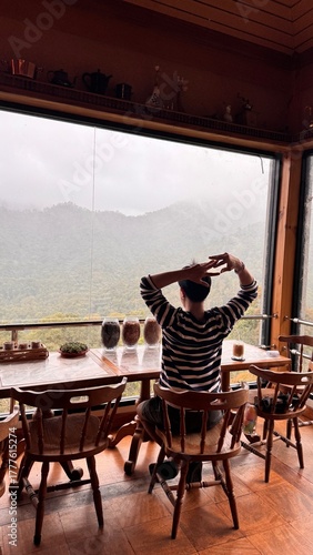 Handsome Man Relaxing in Cafe with Beautiful Morning Misty Valley View