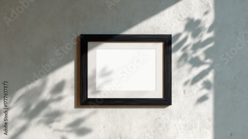 Black rectangular photo frame mockup on an empty wall with natural daylight and smooth texture, perfect for artwork presentation, no text, no logo