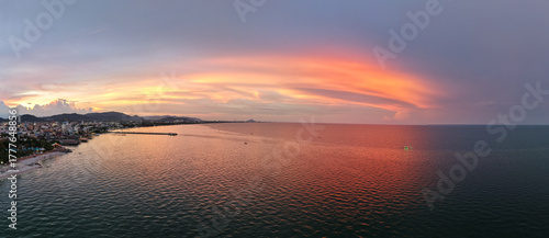 vivid sunset scenery, enchanting shoreline bathed in pink reflections with sweeping cinematic cloud Hua Hin Thailand