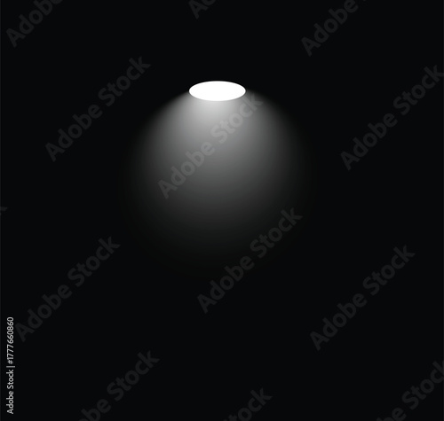 A single, bright spotlight shines down from above, casting a soft, circular pool of light against a deep black background. The light source itself is a brilliant white, gradually fading outwards into 