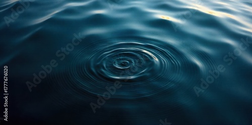 First Ripples on Calm Water A top down, close up view of a perfectly still, dark water surface with subtle, concentric ripples spreading outward. The ripples should be defined by delicate interplay of