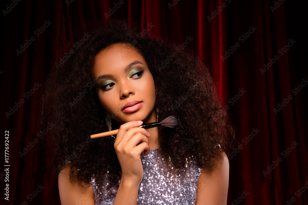 Obraz premium Glamorous Woman with Glamorous Makeup, Sparkling Outfit, and Luxurious Hair Posing Against Red Velvet Backdrop