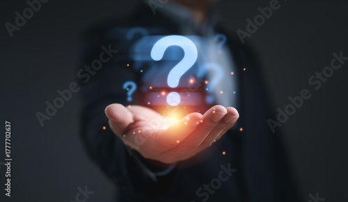 Businessman holding glowing question mark symbol representing problem solving uncertainty curiosity innovation decision making challenge and creative thinking concept in business and technology.