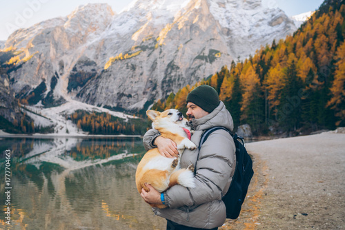 Fototapet Father holds his son while they admire the scenic mountain view with a dog by th