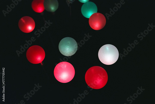 Obraz na plátně Glowing orbs in red, white, and green arranged on dark background