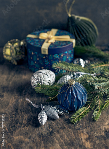 Vintage Christmas decortions, a gift box and spruce twigs on wooden background