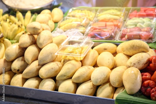 Varied Thai street food collection at a night market featuring grilled seafood, meatballs, and fresh fruit juice. Selection of delicious Asian snacks including grilled octopus, giant prawns, and color