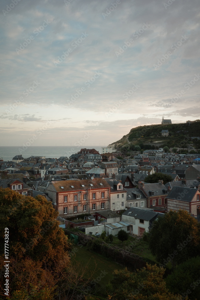 Fototapeta premium Scenic View of French Coastal Town and Hilltop Chapel at Sunset in Normandy, France