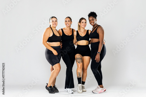 Full photograph of a group of 4 young girls of different ethnicities and body types posing on a white background while looking at the camera.Concept of women in the sports world.