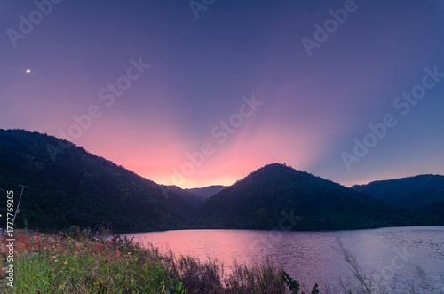 The beauty of the twilight rays over the reservoir and mountains in the countryside of Northern Thailand.