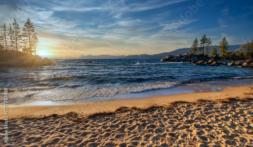 Sand Harbor State Park at Lake Tahoe Nevada USA scenic rocky shoreline with turquoise water and golden sunset light reflecting on waves beautiful outdoor travel destination surrounded by pine trees