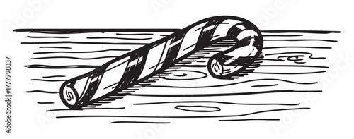Black and white line drawing of a candy cane laying on a wooden surface, with prominent diagonal stripes and a curved hook.