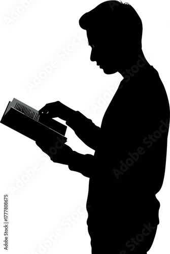 Silhouette of a young man reading a book intently.