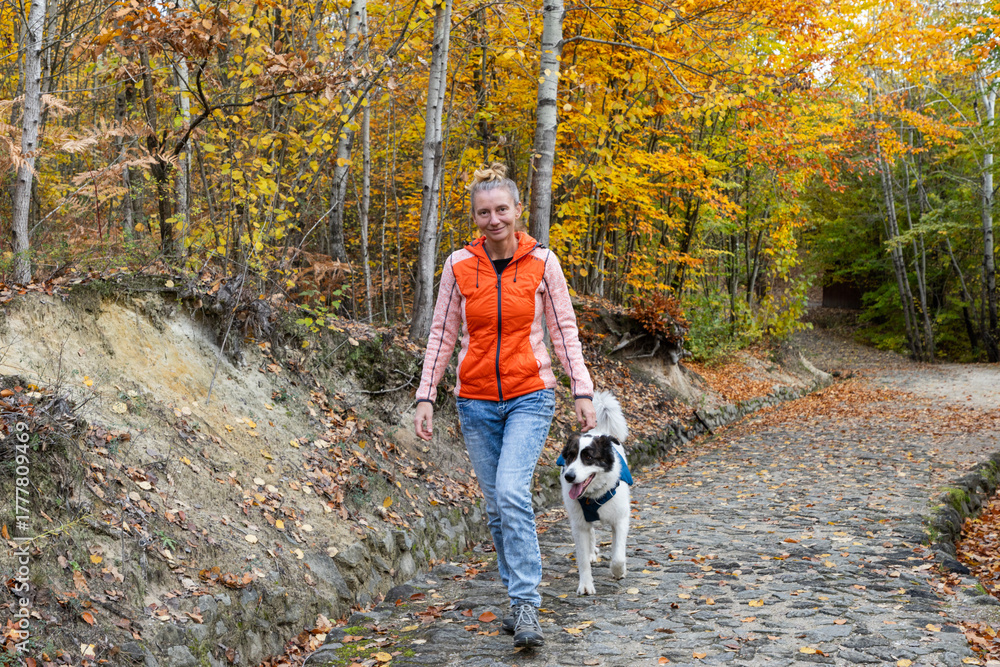 Fototapeta premium happy white dog with owner in autumn forest