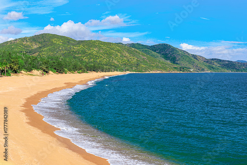 A picturesque view of the beach and mountain at Nianshan Park, Sanya, China.